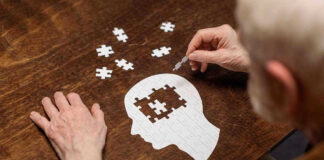 Elderly person completing head-shaped jigsaw puzzle