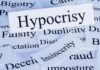 A collection of paper cards with various negative term prominently featuring the word Hypocrisy