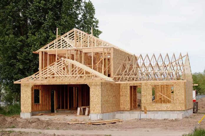 A partially constructed wooden house with exposed framing