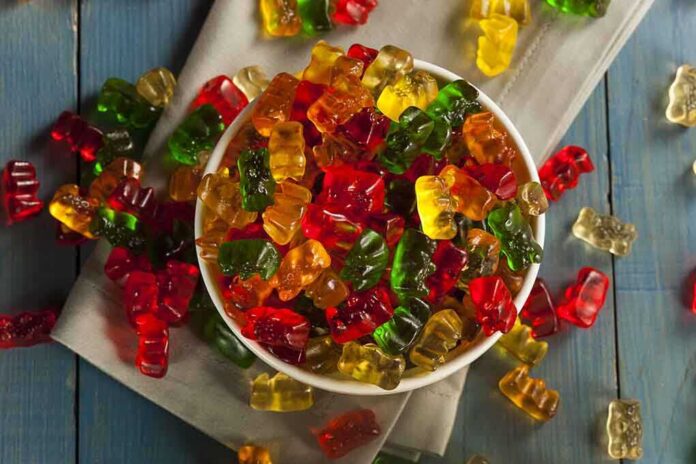 shutterstock_213168391.jpg A bowl filled with colorful gummy bears surrounded by scattered candies