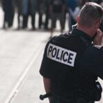 Police officer in uniform communicating with a crowd in an urban setting