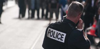 Police officer in uniform communicating with a crowd in an urban setting