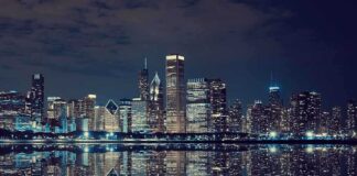 Nighttime view of a city skyline with reflections on water