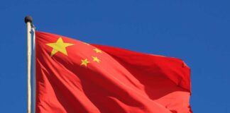 Chinese national flag waving against a clear blue sky