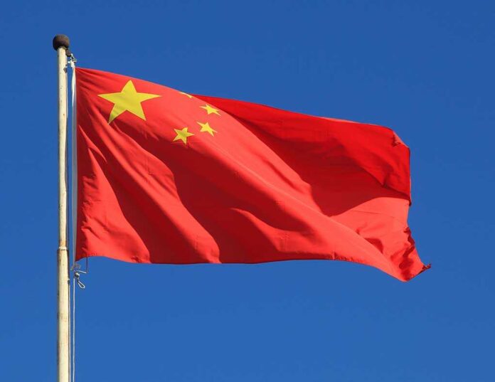 Chinese national flag waving against a clear blue sky