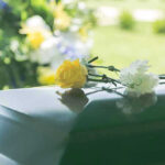 Flowers on a closed casket at a funeral