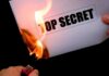 Why So SECRETIVE? — Navy Commandant’s ABRUPT Dismissal A hand holding a lighter igniting a paper labeled TOP SECRET as it catches fire