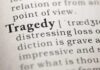 Close-up of the word 'Tragedy' in a dictionary with its definition