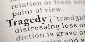 Close-up of the word 'Tragedy' in a dictionary with its definition