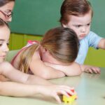 Daycare Horror Exposed—Massachusetts Arrests Stun Parents Children at a table with building blocks, one child appears upset