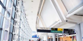 Interior of an airport terminal with travelers and signage