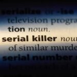 Close-up of a dictionary page showing the definition of 'serial killer'