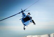 Helicopters SMASH — Witnesses Watch HORROR A helicopter flying over a mountainous landscape against a blue sky
