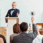 Audience participating in an auction, raising a bid card
