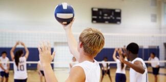 A young athlete preparing to serve a volleyball during practice