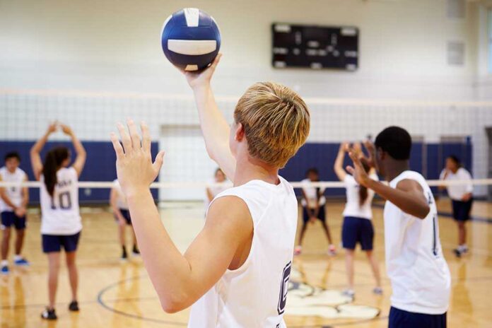 A young athlete preparing to serve a volleyball during practice