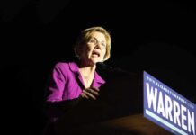 A female politician delivering a speech at a podium with a campaign sign