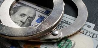 Handcuffs resting on a stack of cash with a 'BAIL' label