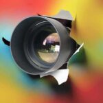 Camera lens protruding through a colorful background