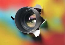 Camera lens protruding through a colorful background