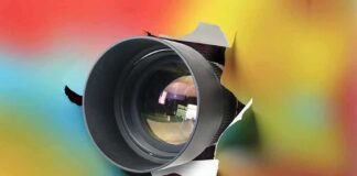Camera lens protruding through a colorful background