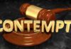 A wooden gavel resting on a circular base with the word CONTEMPT in gold letters