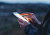 Person using a smartphone at dusk.