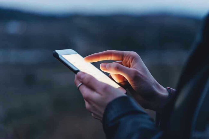 Person using a smartphone at dusk.