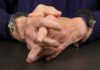 Close-up of hands in handcuffs resting on a table