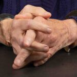 Close-up of hands in handcuffs resting on a table