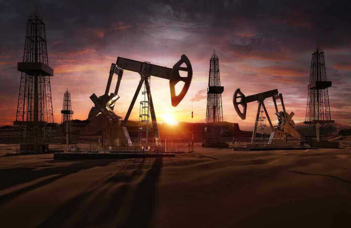 Oil rigs operating at sunset in a desert landscape.