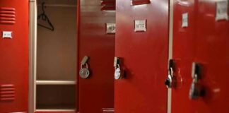 Red lockers with padlocks, one open with hanger.