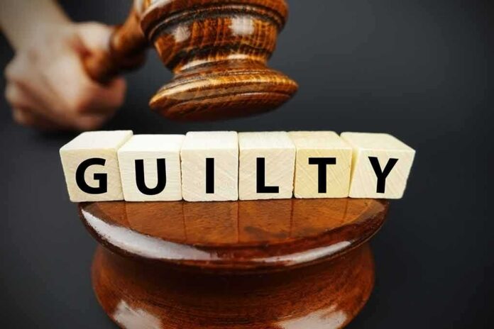 A gavel above wooden blocks spelling 'GUILTY'