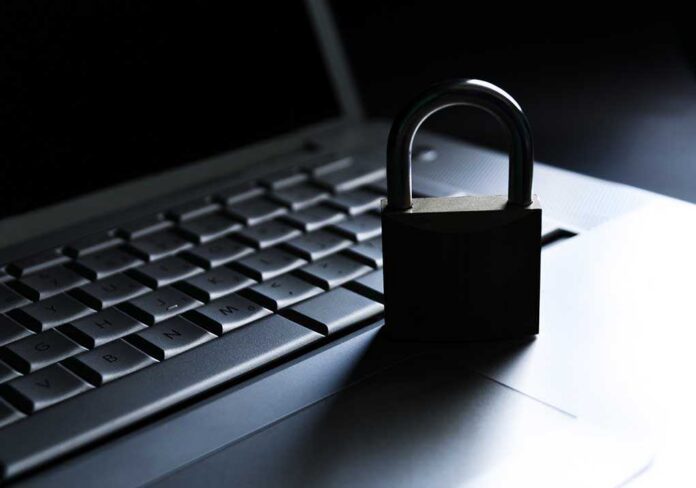 shutterstock_126075611.jpg A padlock resting on a laptop keyboard in a dimly lit environment