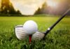 Male-Born Athlete SUES Women’s Golf A golf ball on a tee with a golf club resting beside it on green grass