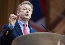 A man in a suit delivering a speech at a podium