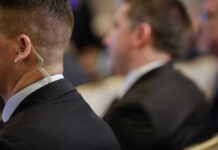 Security personnel with earpiece in a suit.