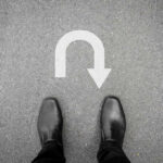 More GOP Defections Shake Mike Johnson’s Math Feet in black shoes facing U-turn road marking.