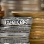 Stack of coins labeled funding with other coins stacks