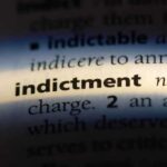 Close-up of a dictionary page showing the word 'indictment' and its definition