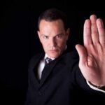 Businessman in a suit making a stop gesture with his hand