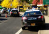 School Graduation Shooting Leaves Teen Dead Police cars and school buses on a road.