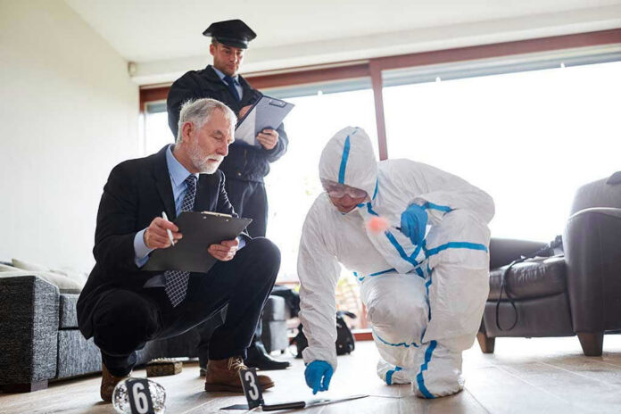 1455188570 Forensic team examining evidence at a crime scene indoors.