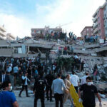 Fears Grow of Far Worse to Come People at a collapsed building after an earthquake.