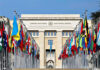 United Nations building with numerous national flags outside.