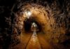 3,000-Foot Cartel Tunnel Exposed Dimly lit underground tunnel with rail tracks and rocky walls