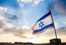 Israel-Hezbollah Conflict Intensifies as Iran Issues Warnings Israeli flag waving against a sunset backdrop with clouds