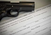 A handgun placed on top of a concealed carry license application form
