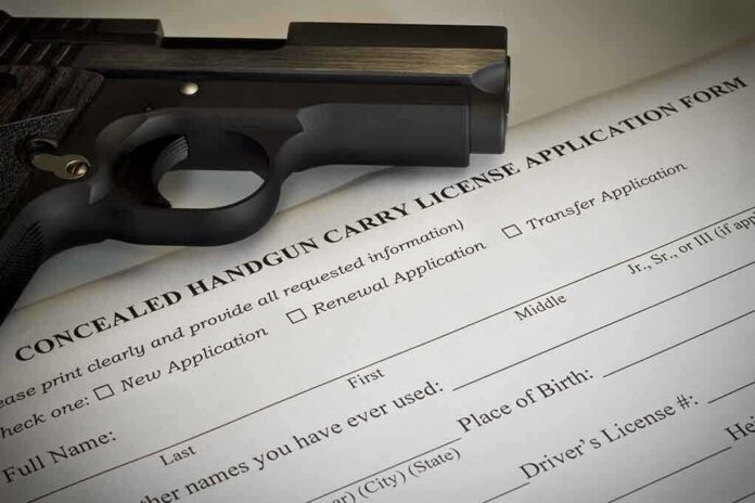 A handgun placed on top of a concealed carry license application form