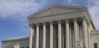The Supreme Court building featuring large columns and statues